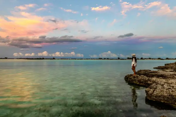 Woman enjoys a beautiful sunset over the water in the Bahamas