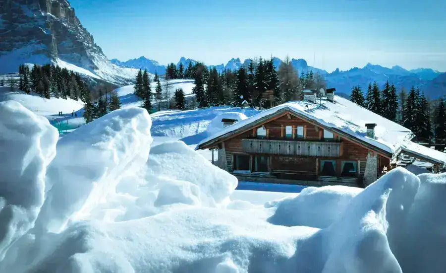 Wooden house beside mountain a snowy landscape