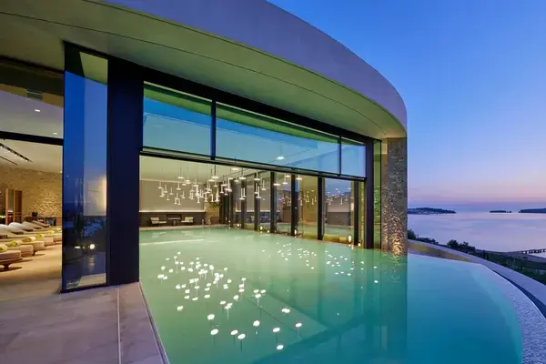 The image shows the indoor and outdoor pools at the Mandarin Oriental spa in Costa Navarino, Greece. 
